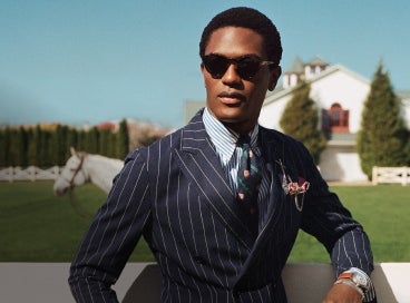 Man wears navy double-breasted pinstripe sport coat.