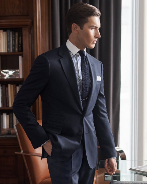 Man in navy suit looking out window