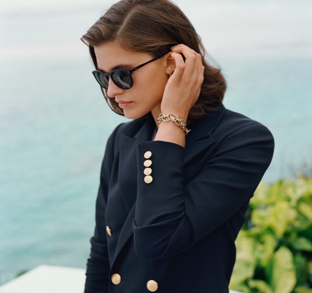 Woman in black frame sunglasses & navy blazer