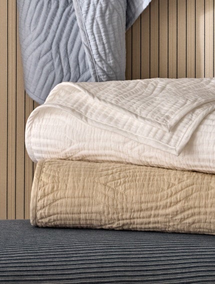 Folded white and beige bedding.