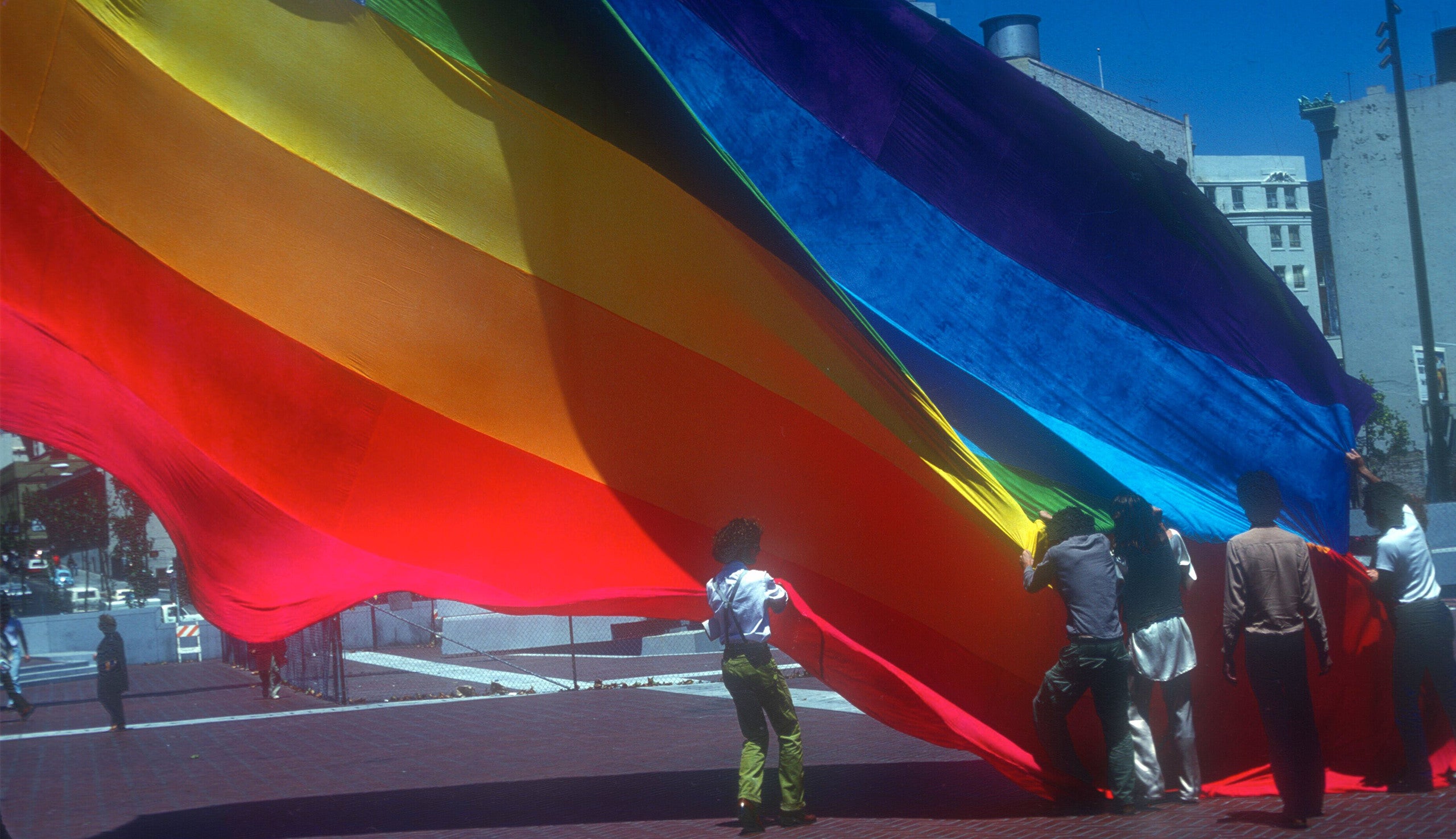 Gilbert Baker and volunteers raising the original Pride flag in San Francisco&rsquo;s United Nations Plaza in 1978