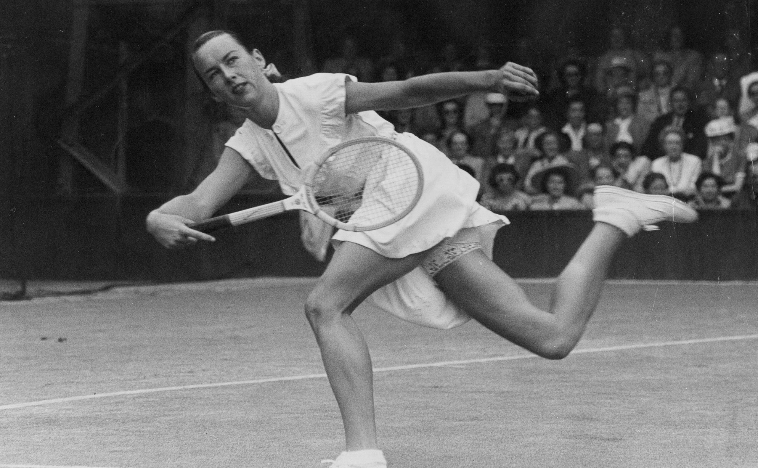 American tennis player Gertrude Moran, or Gorgeous Gussie, on her way to beating F M Wilford at Wimbledon in 1949
