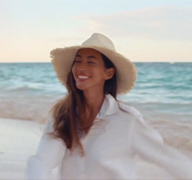 Video of woman in sun hat on beach