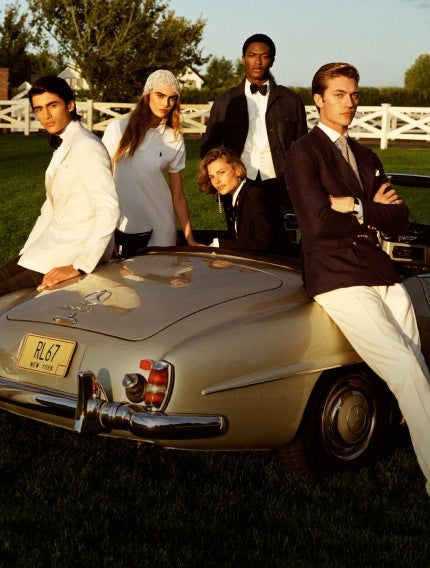 Models gathered around convertible wear black and white Ralph Lauren attire.