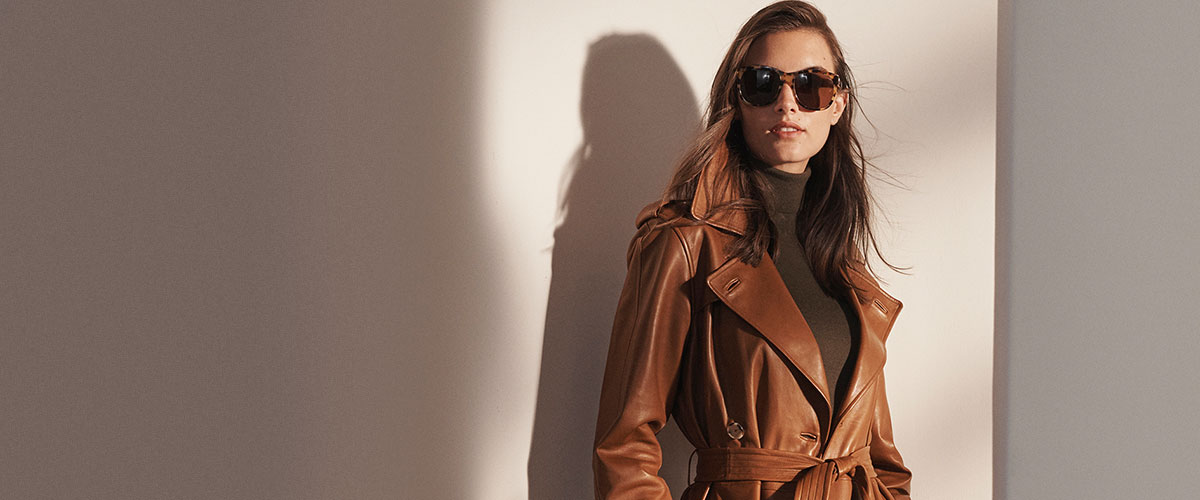Woman in rich brown leather trench coat & tortoiseshell sunglasses