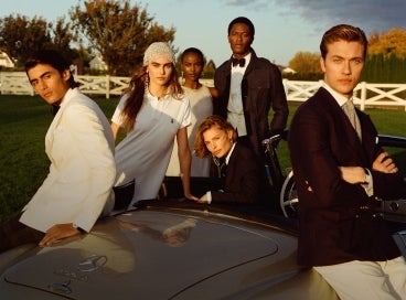 Models gathered around Mercedes convertible wear black and white Ralph Lauren attire.
