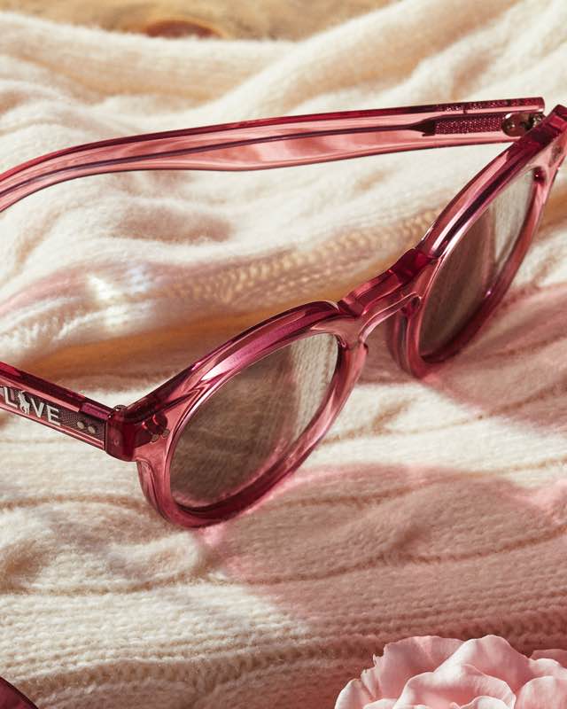 Pink sunglasses on cream cashmere sweater.