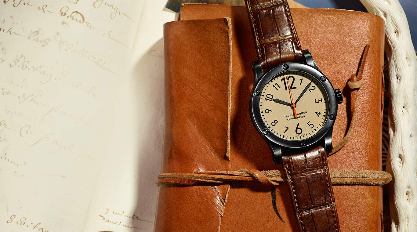 Safari watch lies on leather folio & pages of sepia-toned script