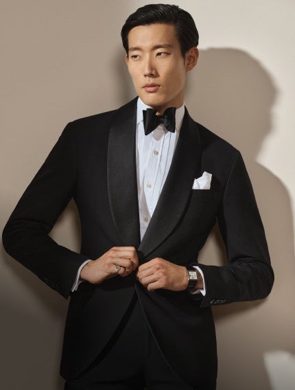 Man wears tuxedo and bow tie.