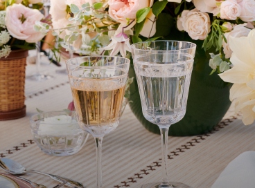 Crystal stemware on table next to floral arrangement.