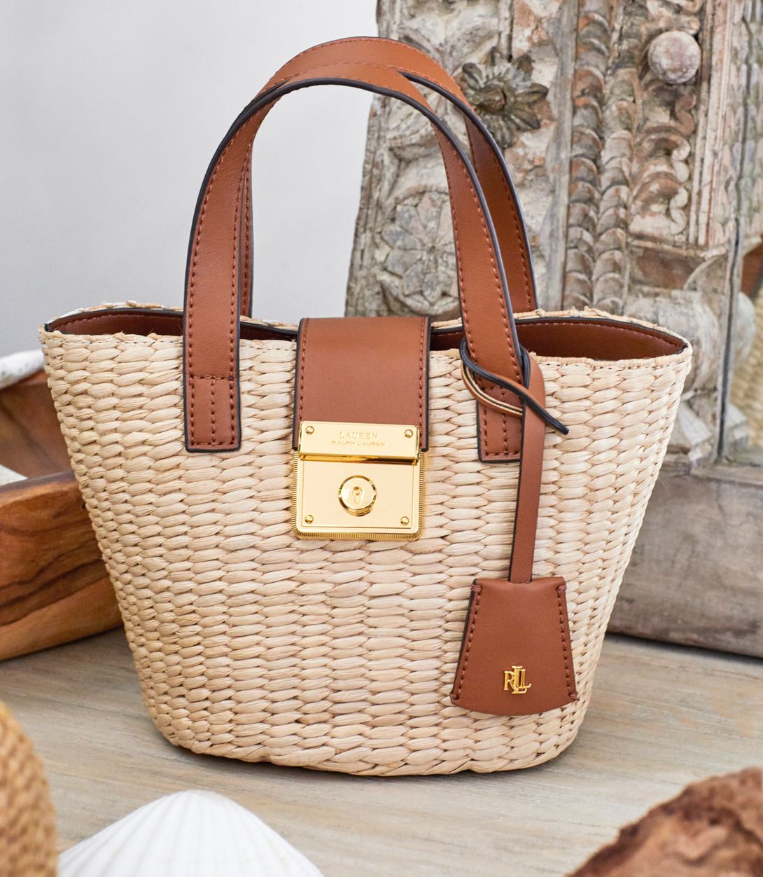 Woven straw bag with brown leather handles.