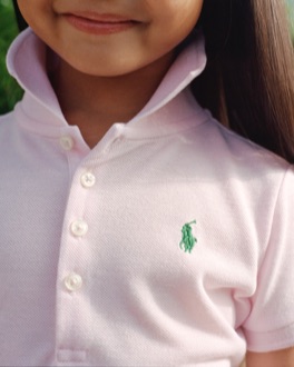 Girl in light pink Earh Polo with green Polo Pony