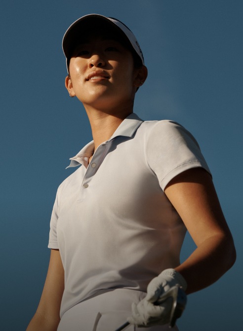 Andrea Lee wears white short-sleeve Polo shirt.