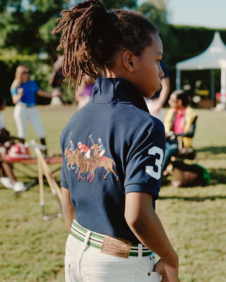 Boy wears navy Polo with equestrian graphic at back.