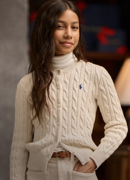 Girl wears white cable-knit cardigan.