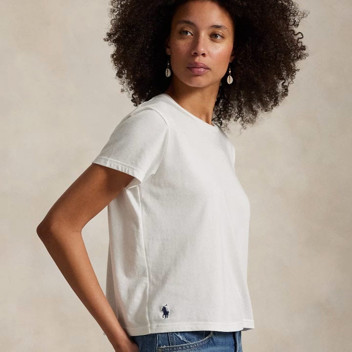 Woman wears white tee and wide-leg jeans.