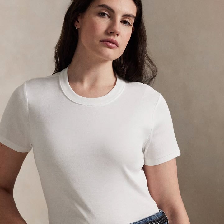 Woman wears fitted white tee and jeans