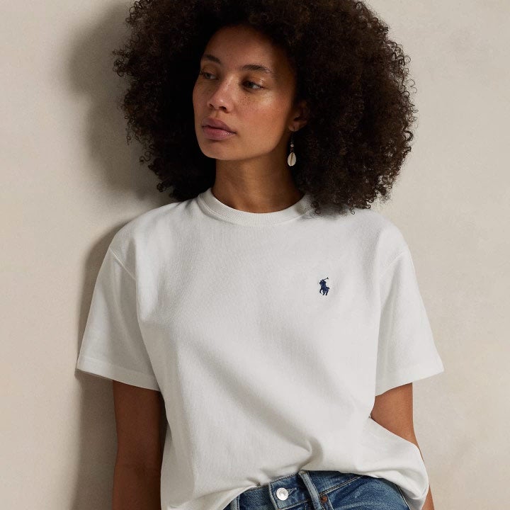 Woman wears roomy white tee and jeans.