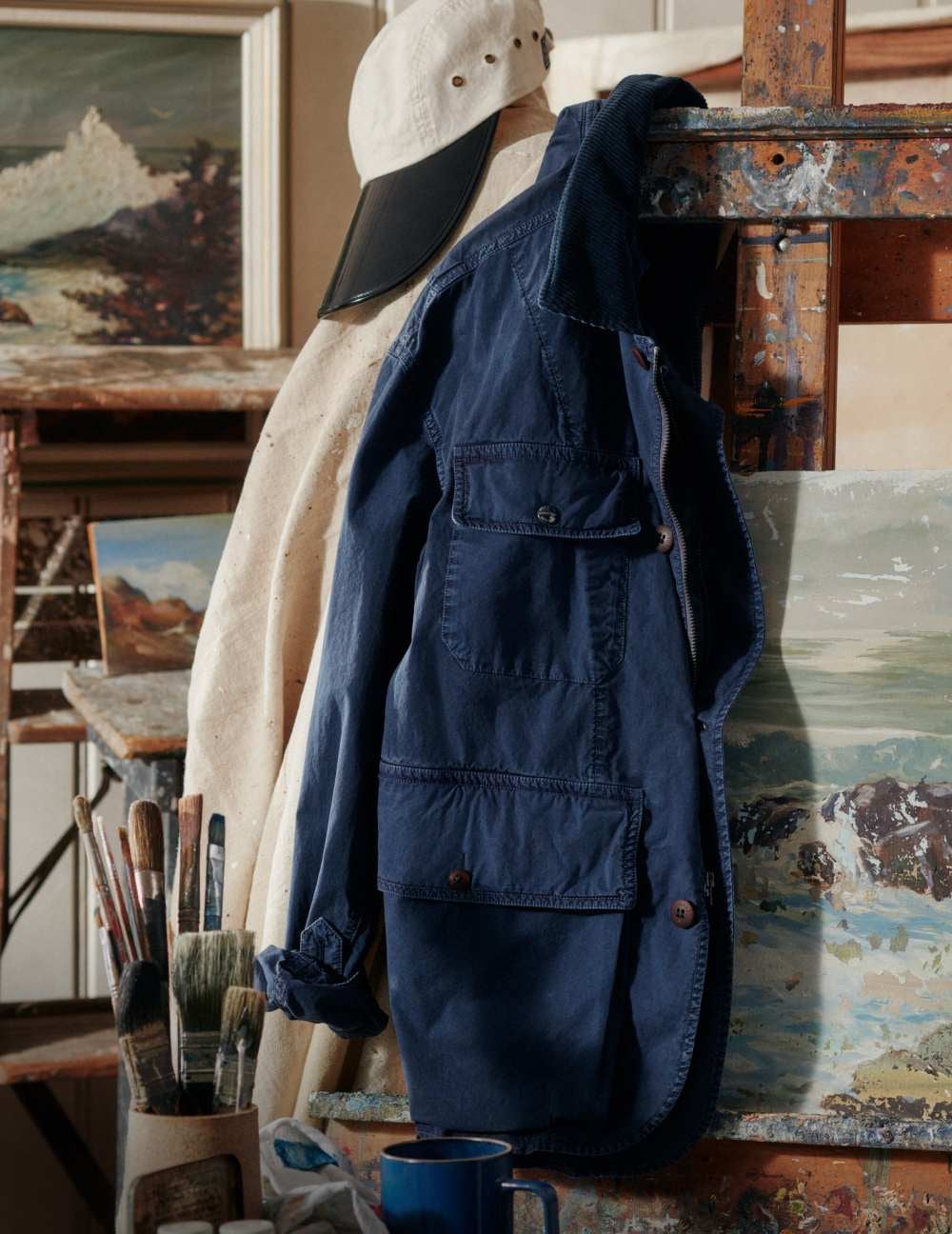 Blue utility jacket hanging on artist&rsquo;s easel.