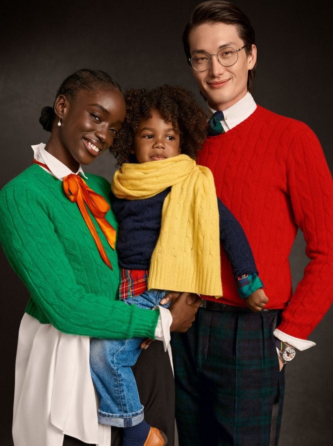 Woman, man, and child wear colorful cable-knit sweaters.