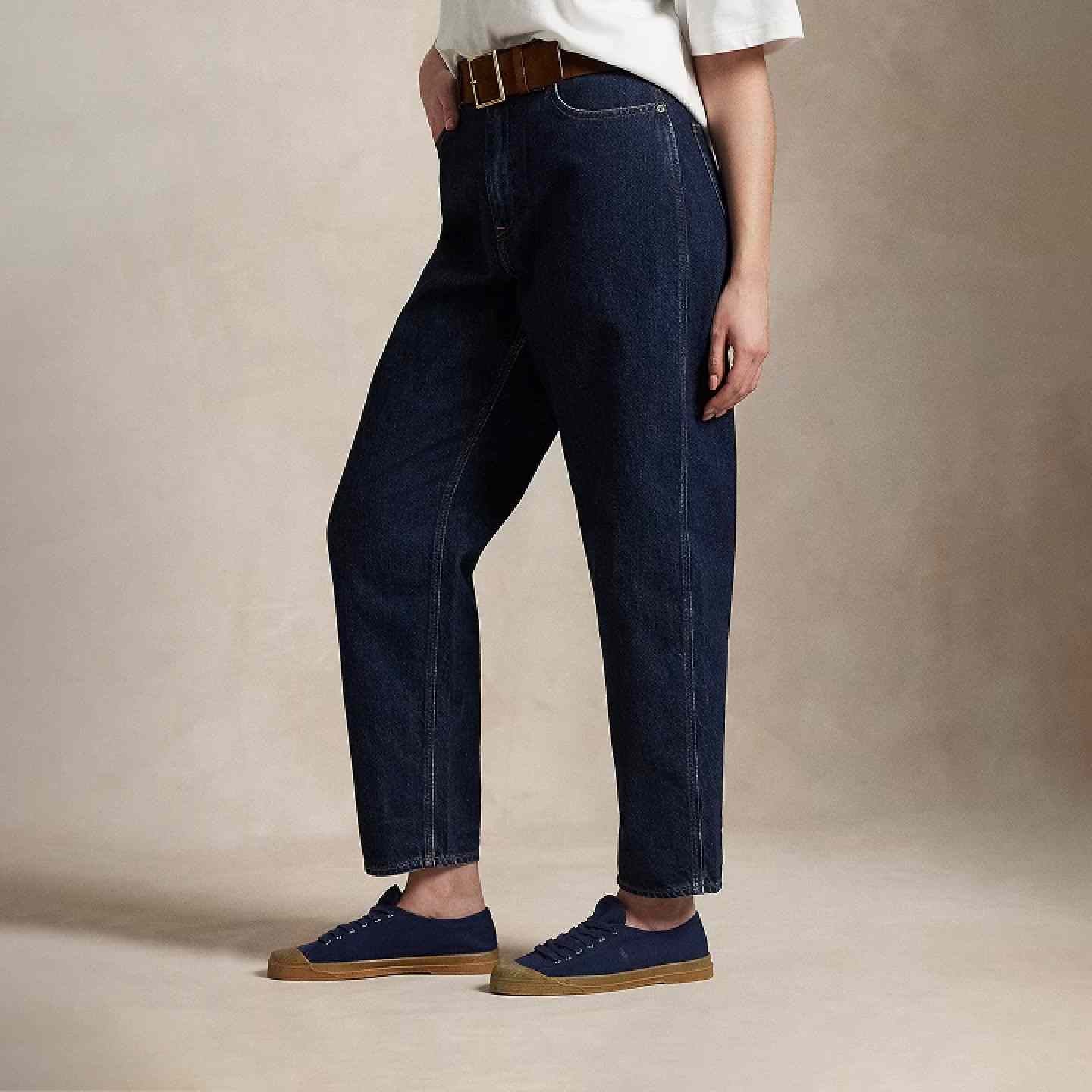 Woman wears tapered jeans and white tee.