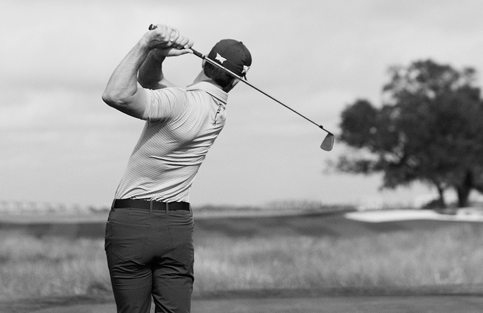 Black-and-white photograph of Billy Horschel swinging golf club.