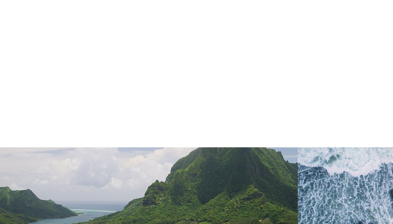 Photograph of lush green mountains and ocean.