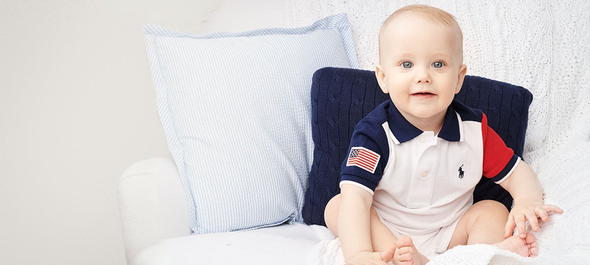 Baby wears American flag-inspired Polo shortall.