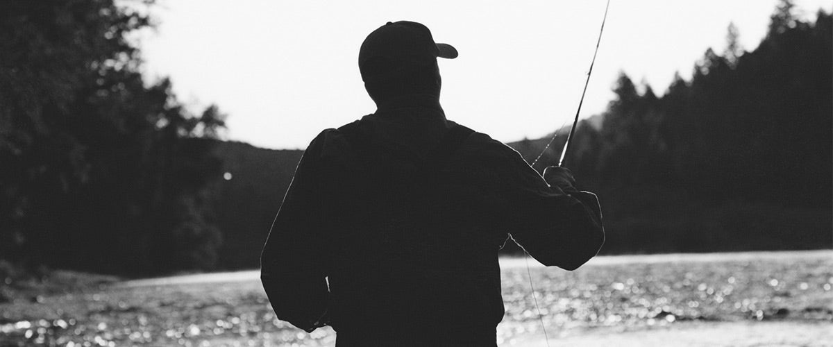 Silhouette of man fly-fishing