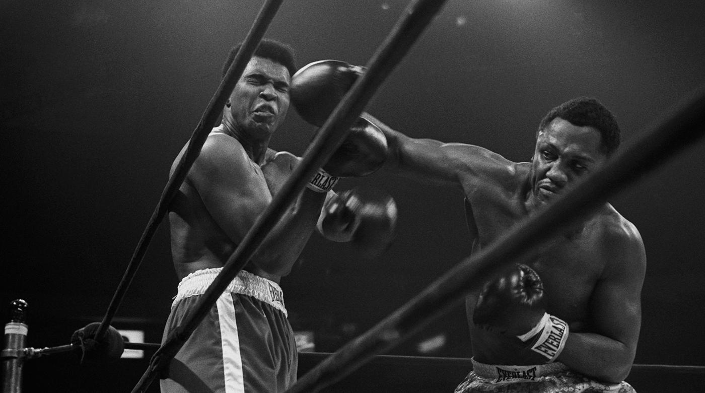Heavyweight champion Joe Frazier delivers a Herculean blow against Muhammad Ali in the Fight of the Century