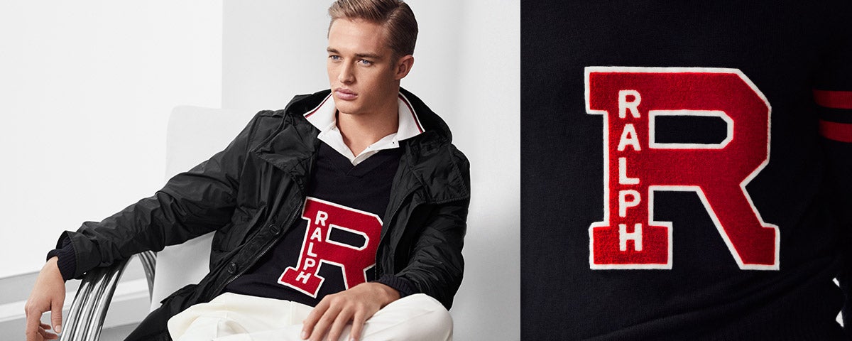 Man in black anorak over knit top with large red "R" patch