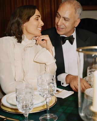 Man & woman in formal wear sitting at table.