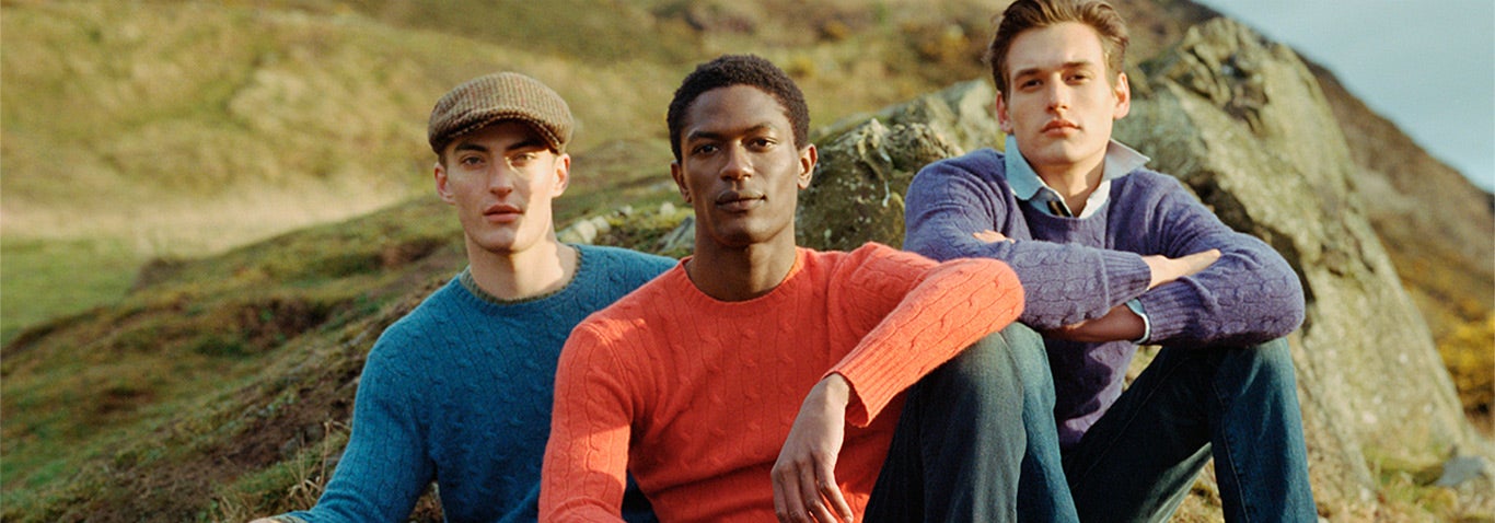 Men in blue, orange & purple sweaters in countryside