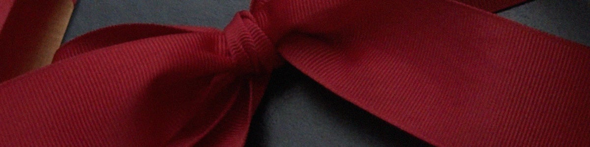 Close-up of red ribbon on navy gift box.