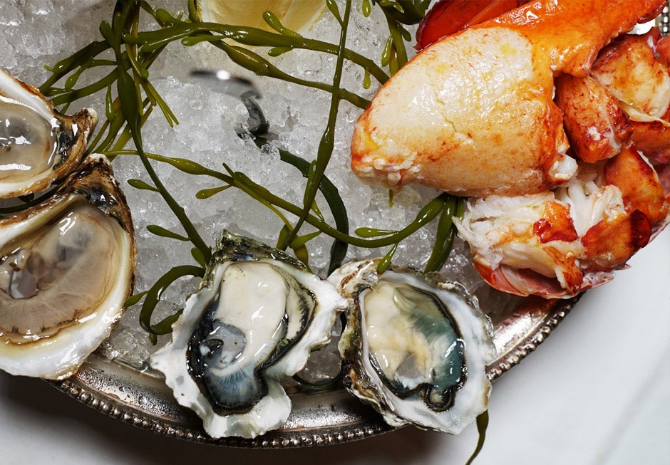 Silver platter with raw oysters and lobster.