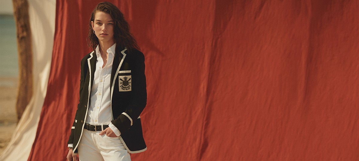 Woman in black blazer with white trim and nautical patch pocket