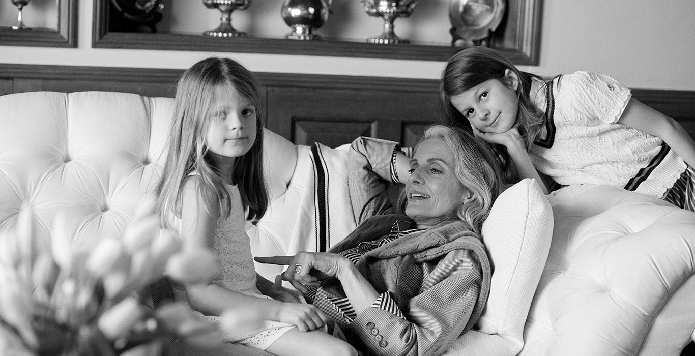Woman in blazer & striped shirt with granddaughters