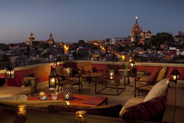 The open-air space is lit by candles and the glow from the city below