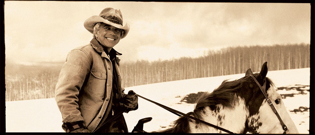 Sepia-tone photograph of Ralph Lauren riding horse.