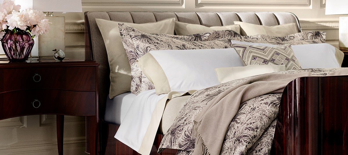 Bed appointed with neutral-hued damask-patterned comforter