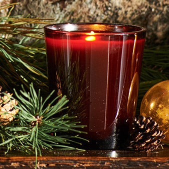 Lit candle in red glass vessel