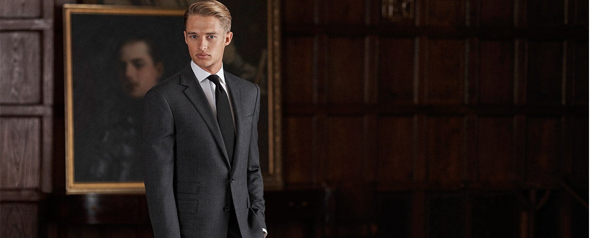 Man in sleek black suit in dark room