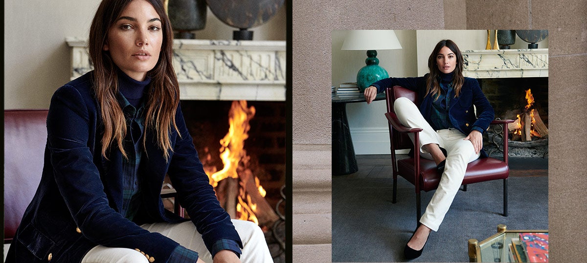 Woman in navy blazer sits by fireplace