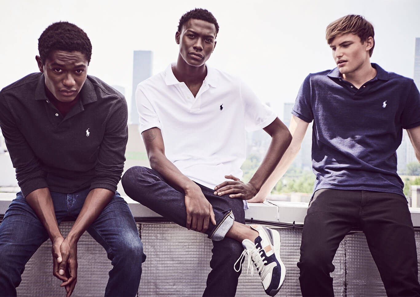 Three men on rooftop in black, white & navy Polo shirts