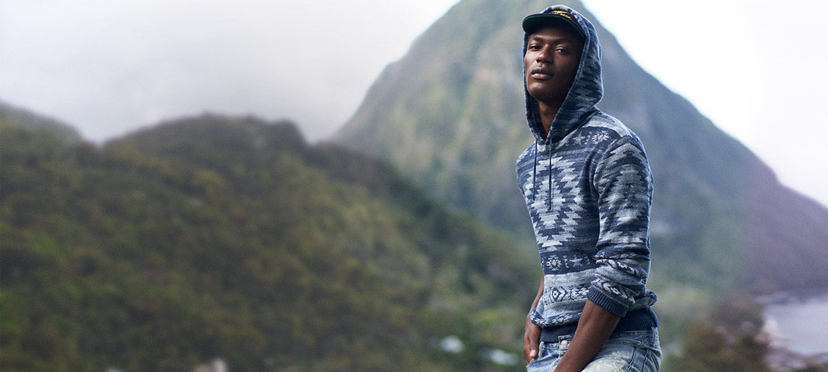 Model outdoors in hooded sweater with Southwestern-inspired indigo motifs