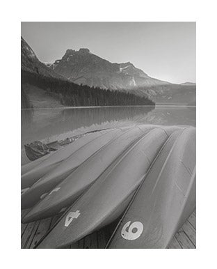 Greyscale photograph of surf boards on beach