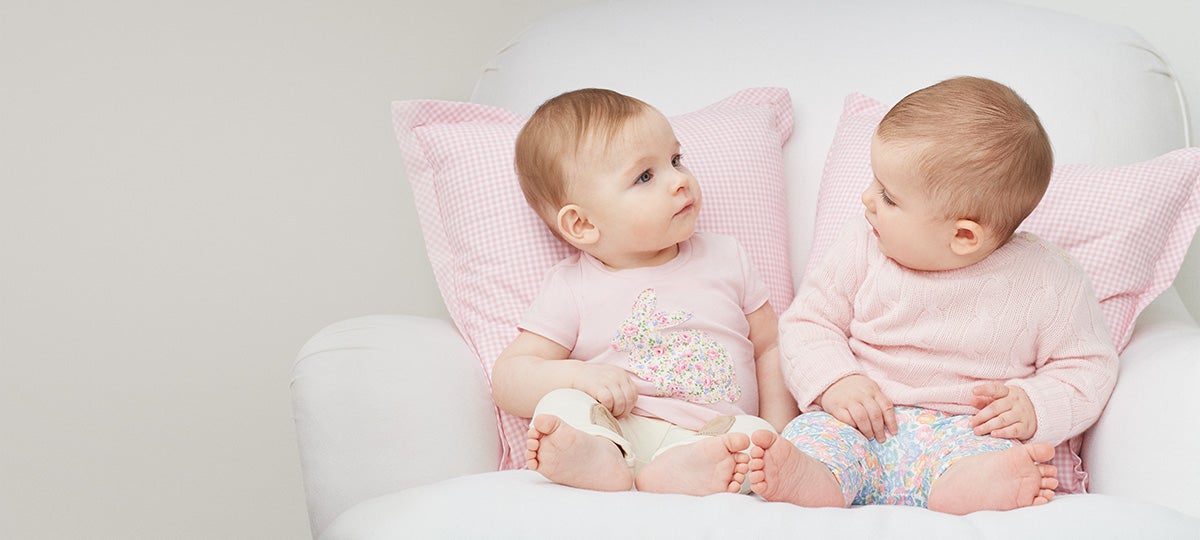 Babies wear light pink and pastel floral outfits.