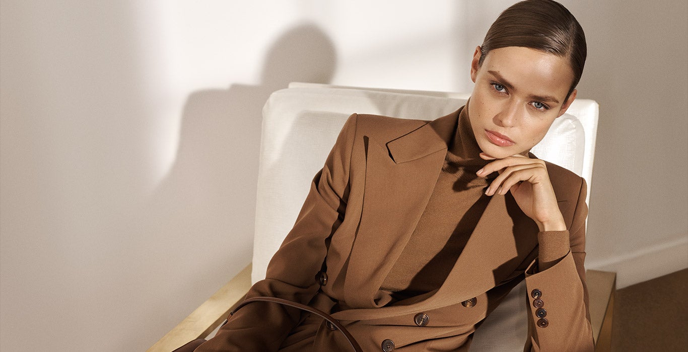 Woman in rich brown blazer paired with tonal turtleneck