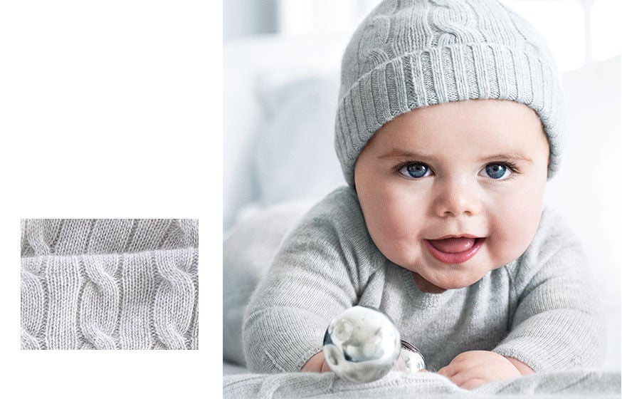 Left: Close-up of cable-knit cashmere. Right: Baby wears grey knit coverall & grey cable-knit hat
