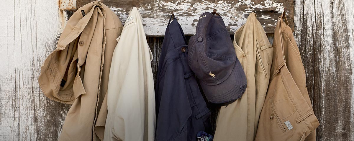 Khaki pants in tan & navy on hooks in row